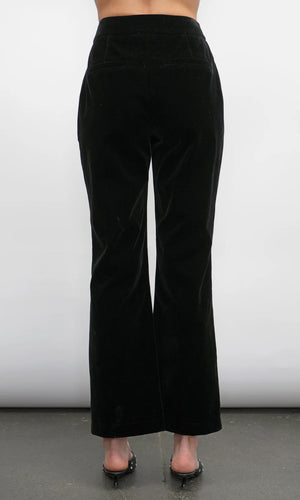 Black velvet pants worn by a person on a white background