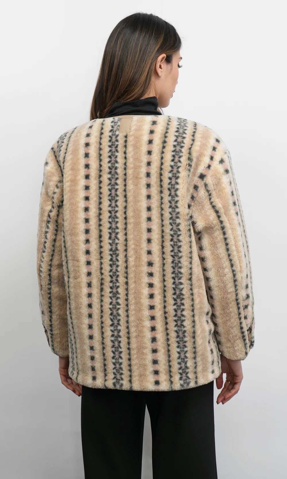 Person wearing a patterned beige jacket on a white background