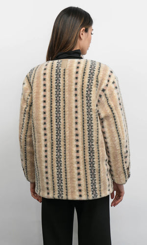 Person wearing a patterned beige jacket on a white background