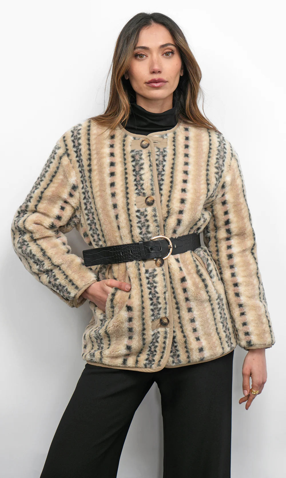 Woman wearing a patterned beige jacket with a belt on a white background