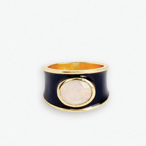 Make a bold statement with the Hazel Oval Stone with Enamel Band Ring. This cocktail ring features an oval-shaped semi-precious stone, such as Black Onyx, Red Jade, Green Onyx, Rainbow Moonstone, or other colors, surrounded by an enamel band. It adds a touch of sophistication and elegance to any outfit.