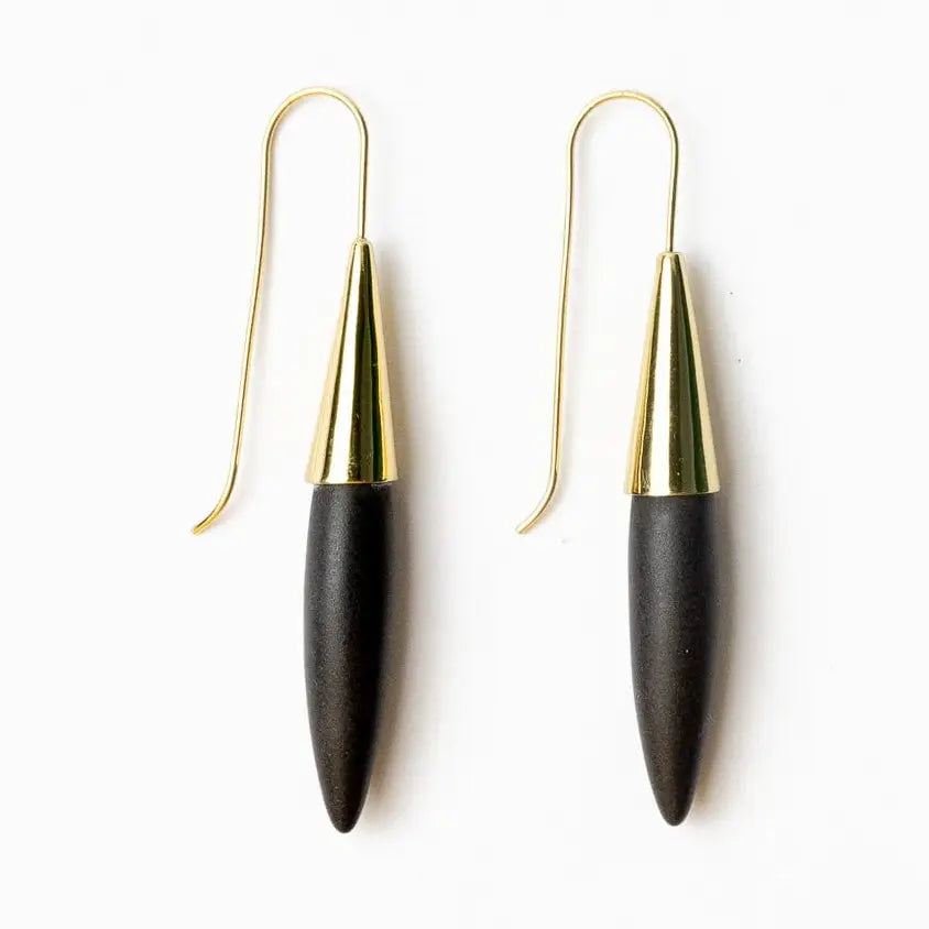 Pair of black earrings with gold tops on a white background