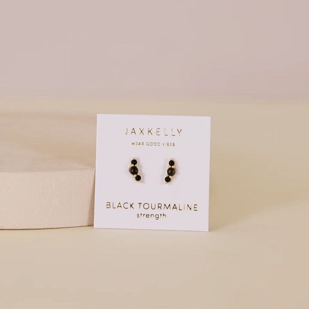 Pair of black tourmaline earrings on a Jaxkelly branded card with a beige background