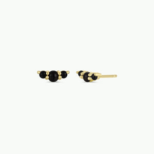 Gold earrings with black beads on a white background