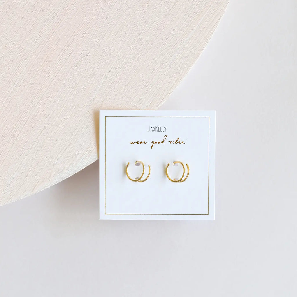Gold hoop earrings on a white card with 'Jamelie' branding on a light background