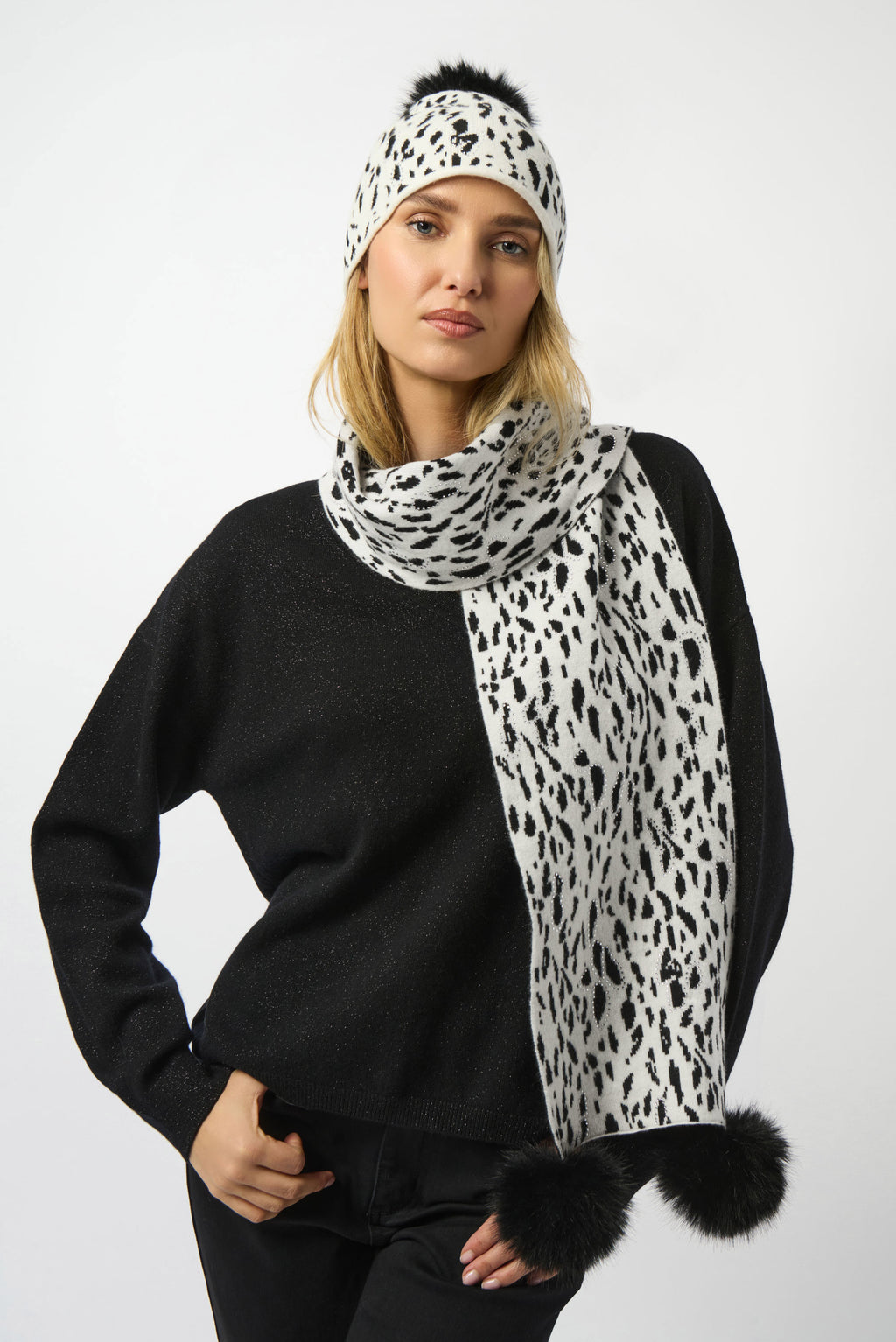 Woman wearing a black sweater with a white and black leopard print scarf and headband.