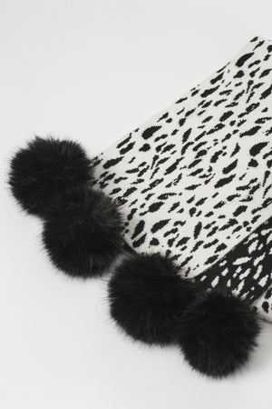 Black fur pom-poms on a white background