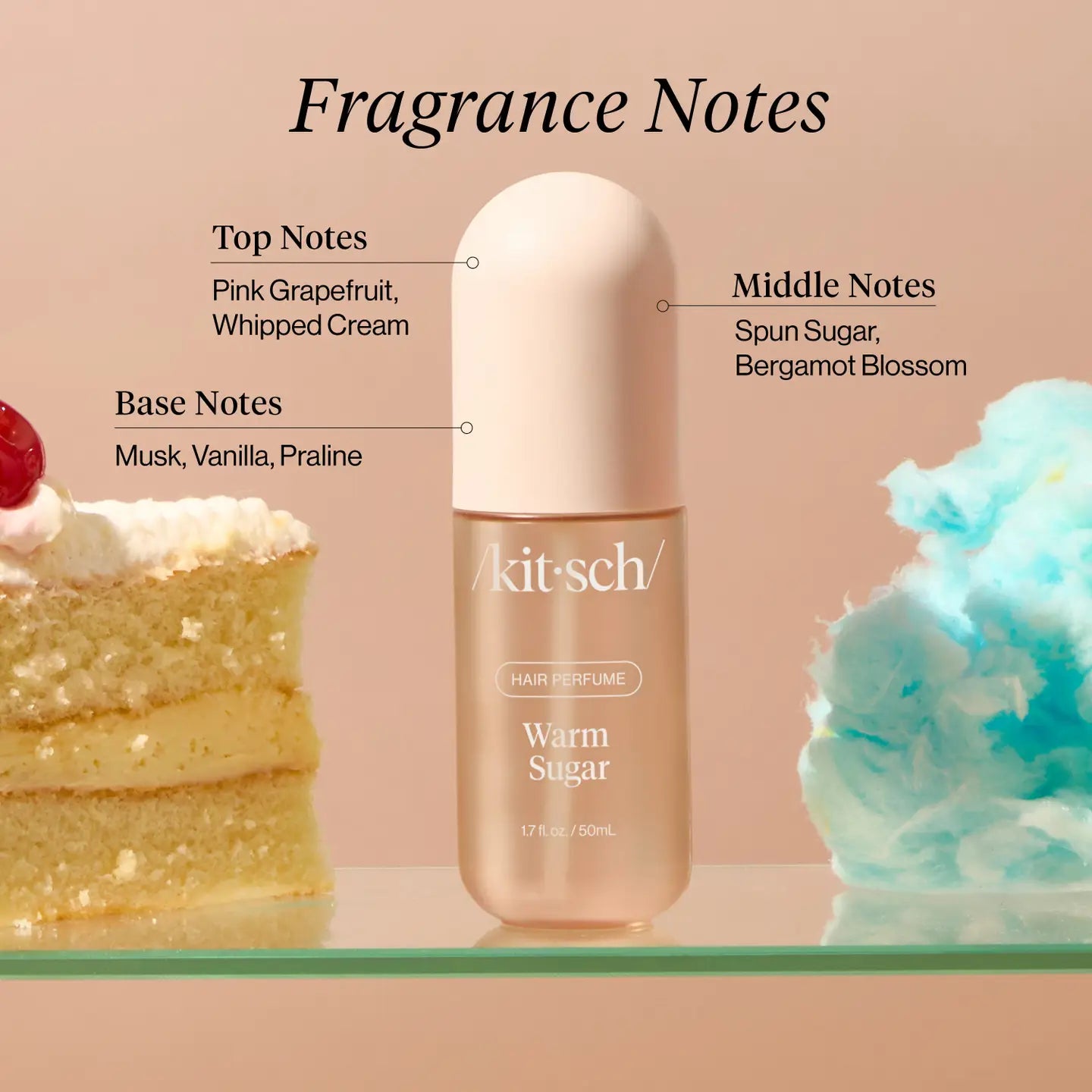 Kitsch hair perfume bottle with fragrance notes labeled next to a cake and cloud-like substance on a pink background