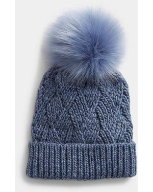 Blue knit beanie with a large pom-pom on a white background