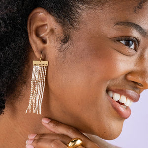 Embrace a playful color-blocked style with the Luxe Brass Lana. These brass earrings feature a combination of ivory and gold tones, topped with a brass bar for added visual interest. The color-blocked fringe design is filled with funky mini-stripes, adding a touch of uniqueness and flair. With a length of 2.85" and a width of .72", these hanger earrings make a stylish and statement-making accessory.