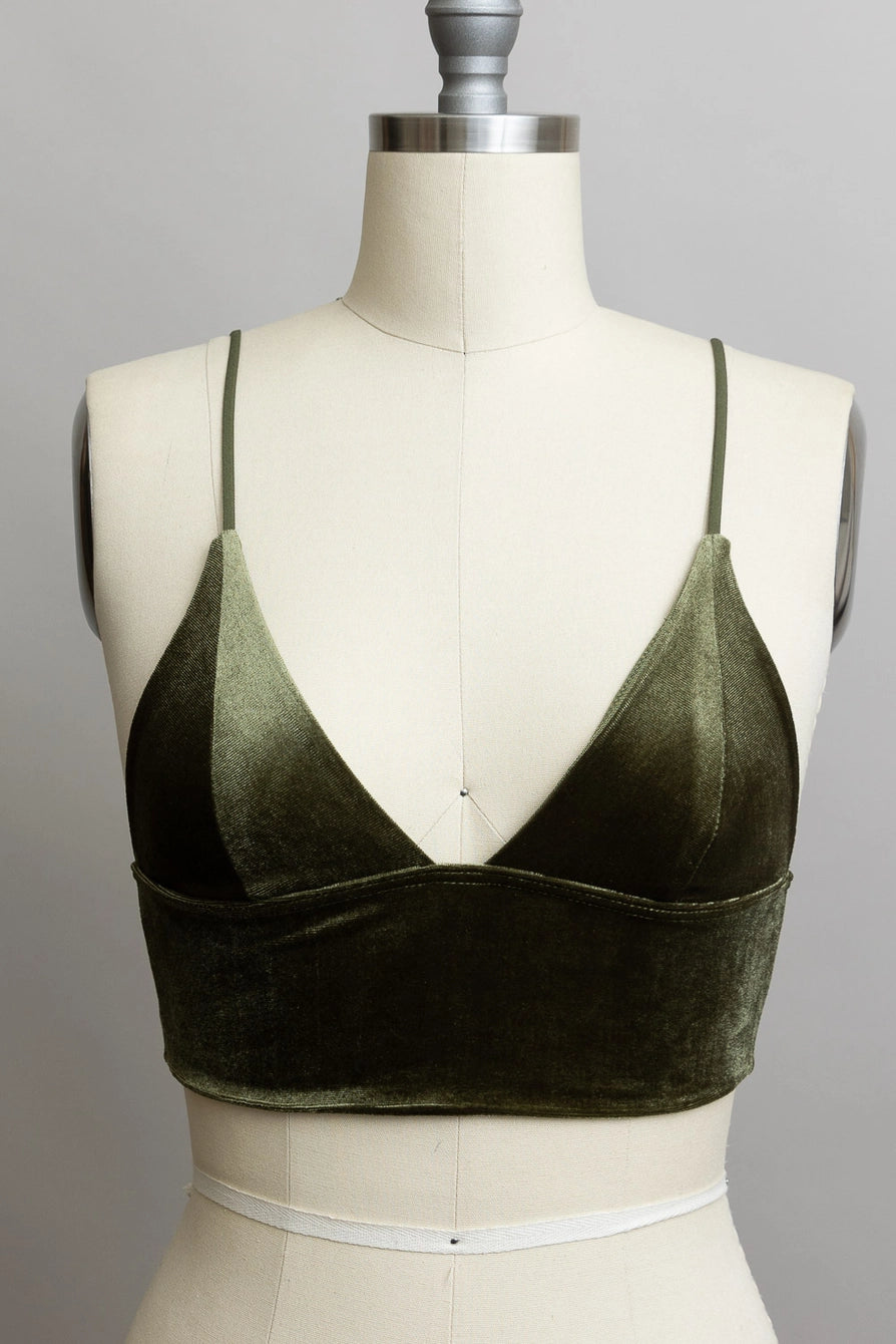 Green velvet bralette on a mannequin against a gray background