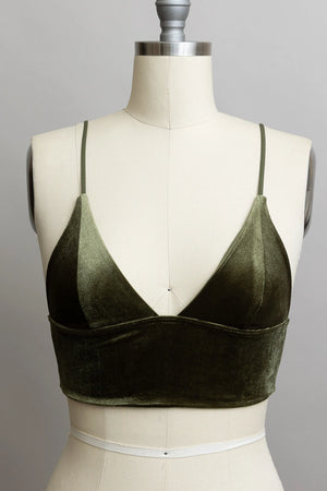 Green velvet bralette on a mannequin against a gray background