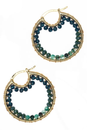 Gold hoop earrings with green gemstones on a white background