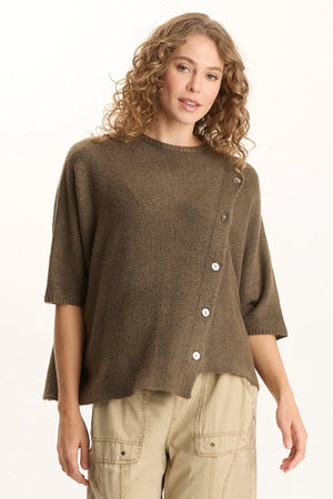 Woman wearing a brown button-up sweater over a beige shirt on a white background