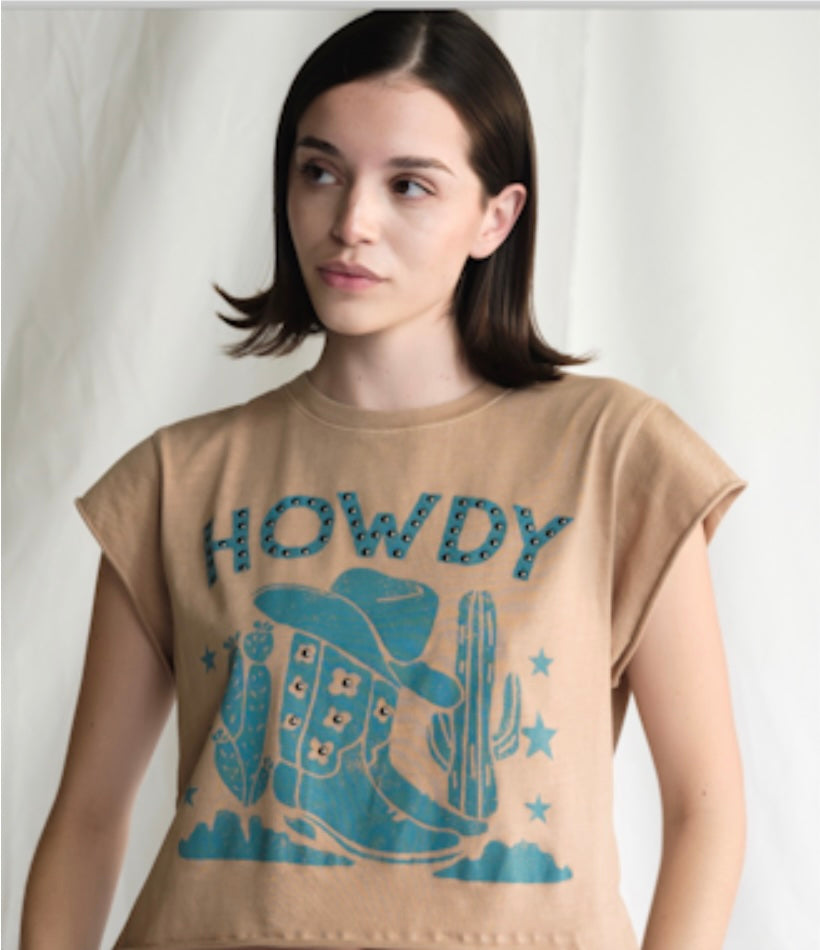 Woman wearing a beige t-shirt with blue graphics and text on a plain background
