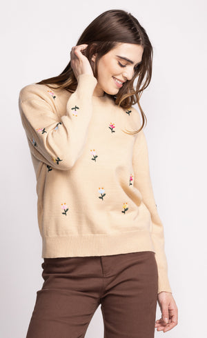 Add a touch of whimsy to your wardrobe with the Pink Martini Eva sweater. This crew neck design features charming embroidered flower details, perfect for adding a playful element to any outfit. Stay cozy and stylish with this unique and fun sweater.