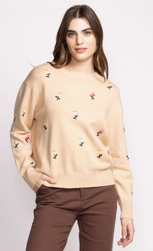 Add a touch of whimsy to your wardrobe with the Pink Martini Eva sweater. This crew neck design features charming embroidered flower details, perfect for adding a playful element to any outfit. Stay cozy and stylish with this unique and fun sweater.