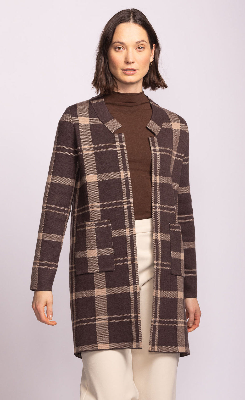 Woman wearing a plaid coat on a white background