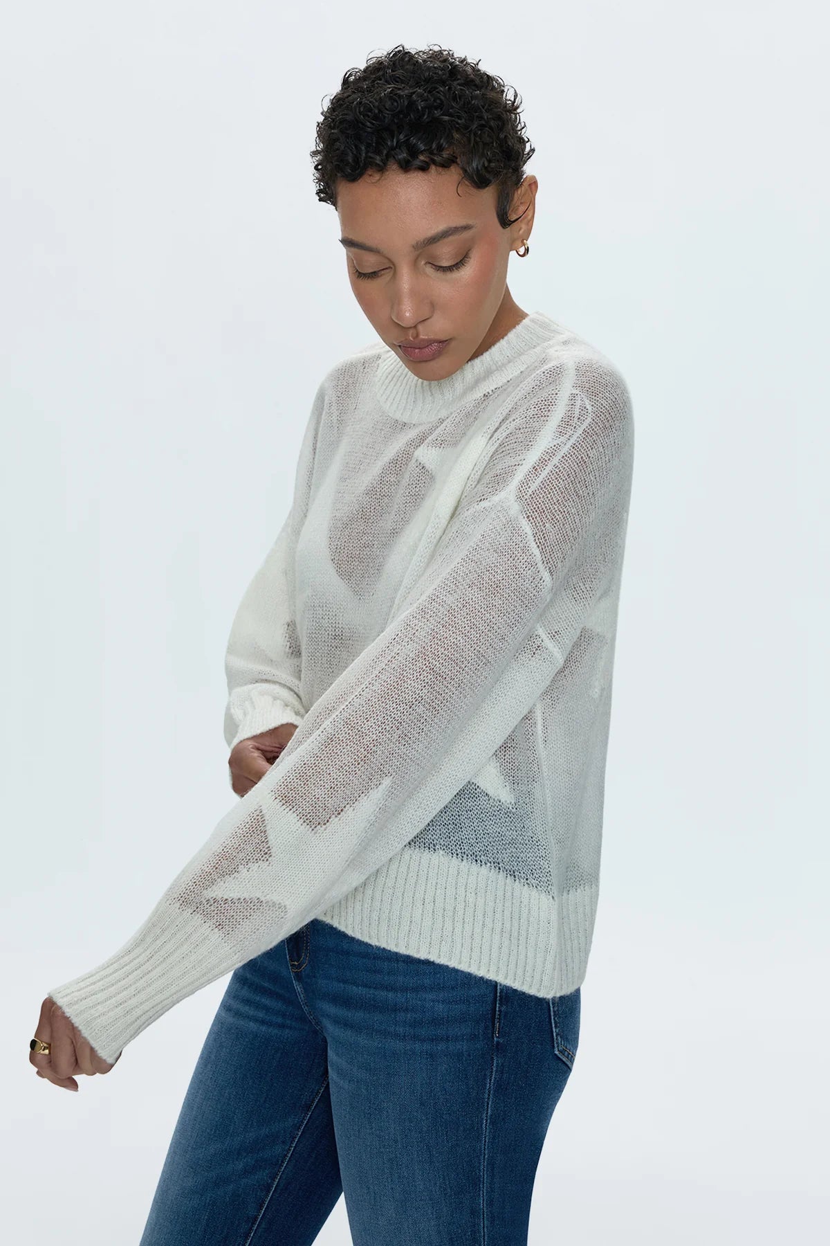 Star power. Ultra lightweight, open knit sheer pullover sweater. With a relaxed, scooped neckline and asymmetrical high low hem. With relaxed single layer ribbing at neckline, cuffs, and hem. Decorated with monochromatic star print motif throughout.&nbsp;