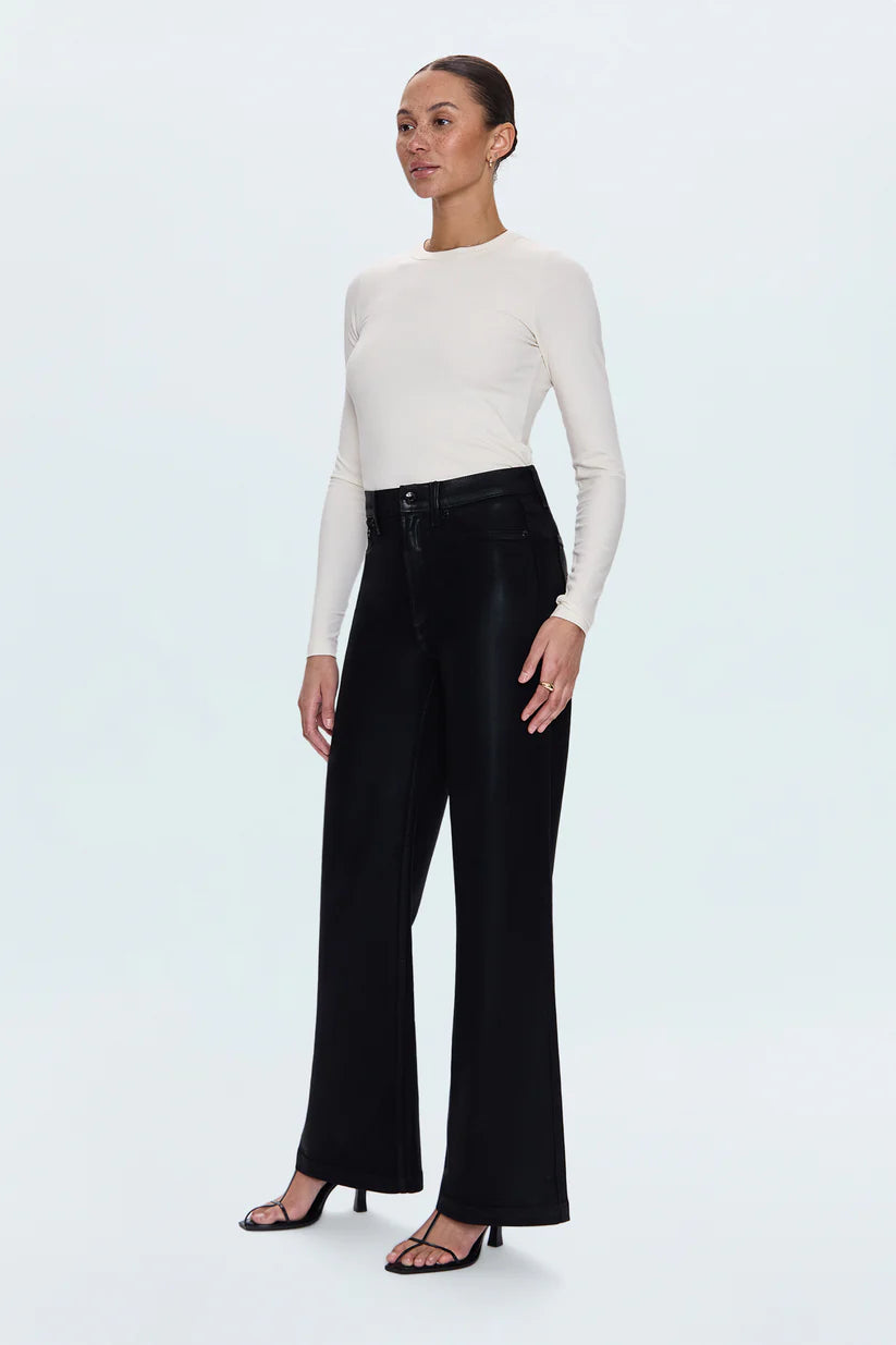 Woman wearing a white long-sleeve top and black wide-leg pants on a white background