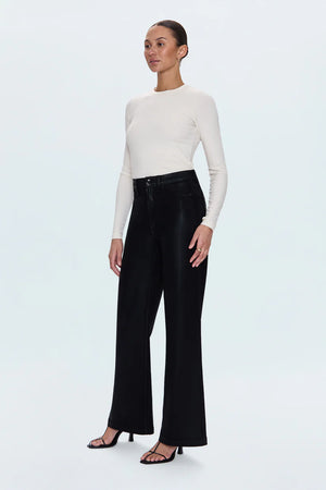 Woman wearing a white long-sleeve top and black wide-leg pants on a white background