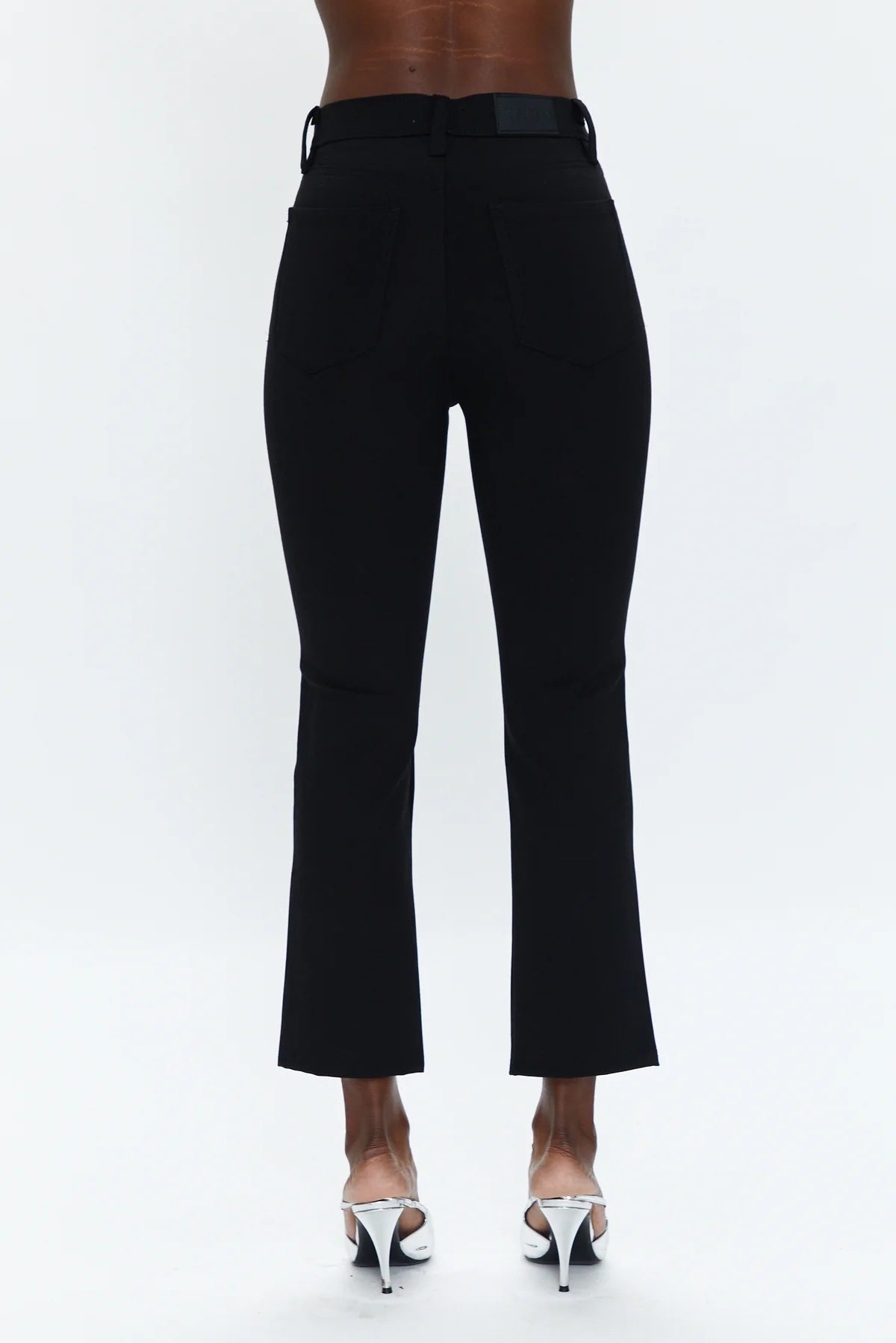 A chic pant you can everywhere, all the time. In a cropped boot cut fit, it hugs you from the hips to knee and flares out right above the calf for a proportional effect. Featured in a rich saturated black with center front slits at the hem, this pant is made in our super stretchy Ponte fabric that comfortably holds you in.