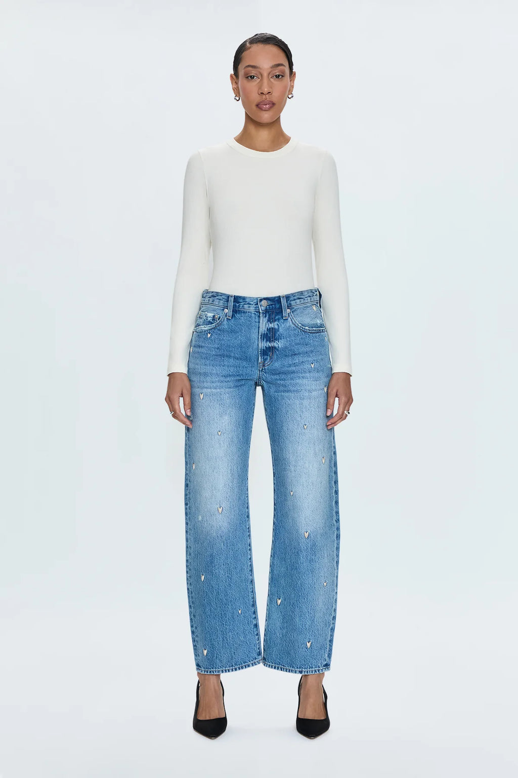 Mid-rise, straight leg with a subtle bow at the thigh and knee for an elevated barrel leg silhouette. Ankle length crop with a clean finish hem, crafted from rigid non-stretch denim for an expert fit that holds its shape. Confetti Vintage is a medium blue wash adorned with an embroidered heart motif throughout and minor hints of distressing.