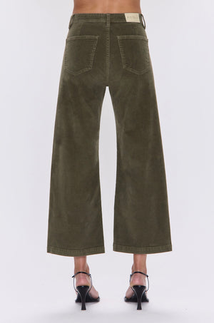 Green wide-leg pants worn by a person on a white background