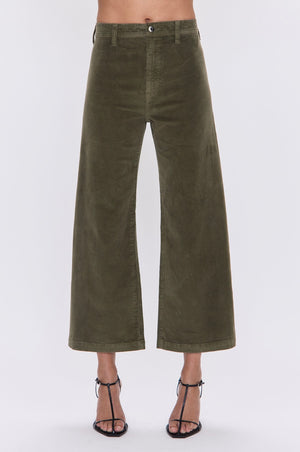Green wide-leg pants worn by a person on a white background