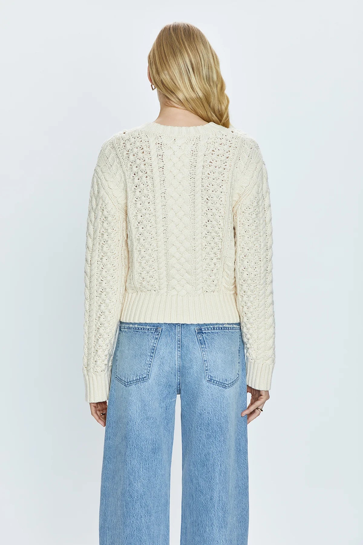 Crewneck pullover sweater with a relaxed, shrunken silhouette. Crafted with mixed cable open knit-work for textural dimension and medium weight wearability. Finished with single layer ribbed neckline, hem, and cuffs and offered in a warm, ivory colorway.