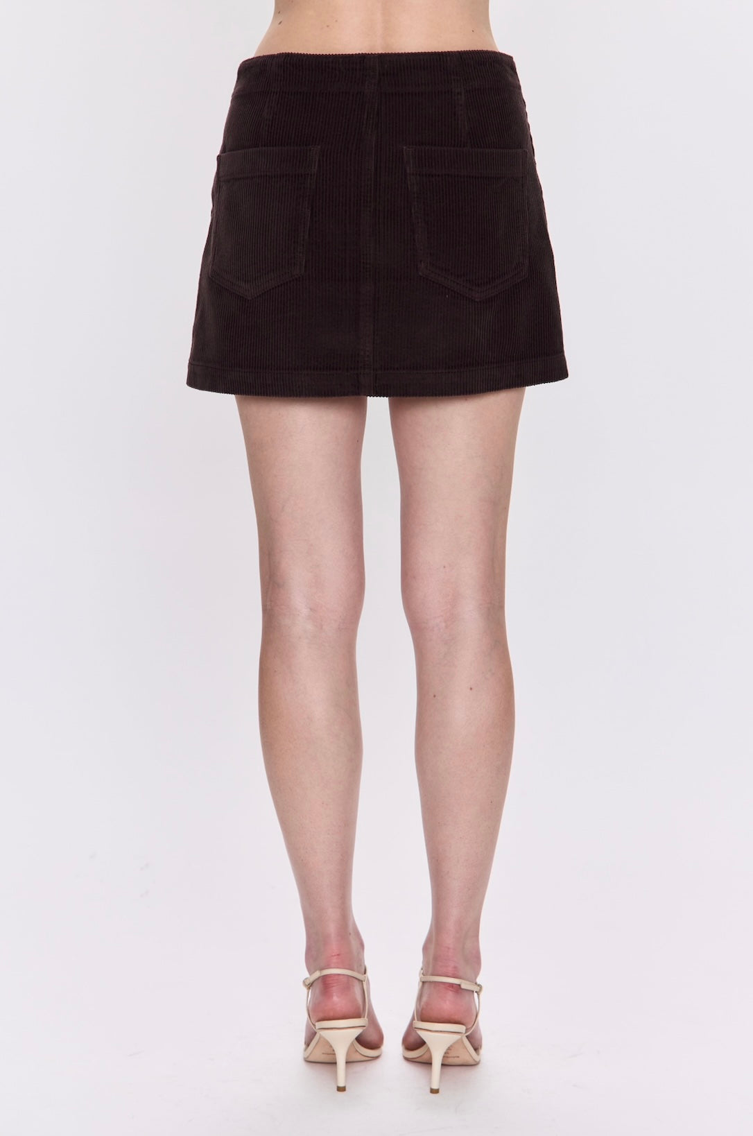 Brown mini skirt worn by a person on a white background