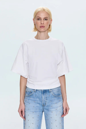 Person wearing a white t-shirt and light blue jeans on a plain background