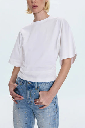 Person wearing a white t-shirt and blue jeans on a light gray background