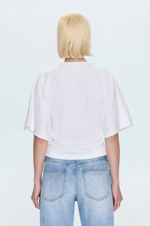 Person wearing a white t-shirt and light blue jeans on a white background