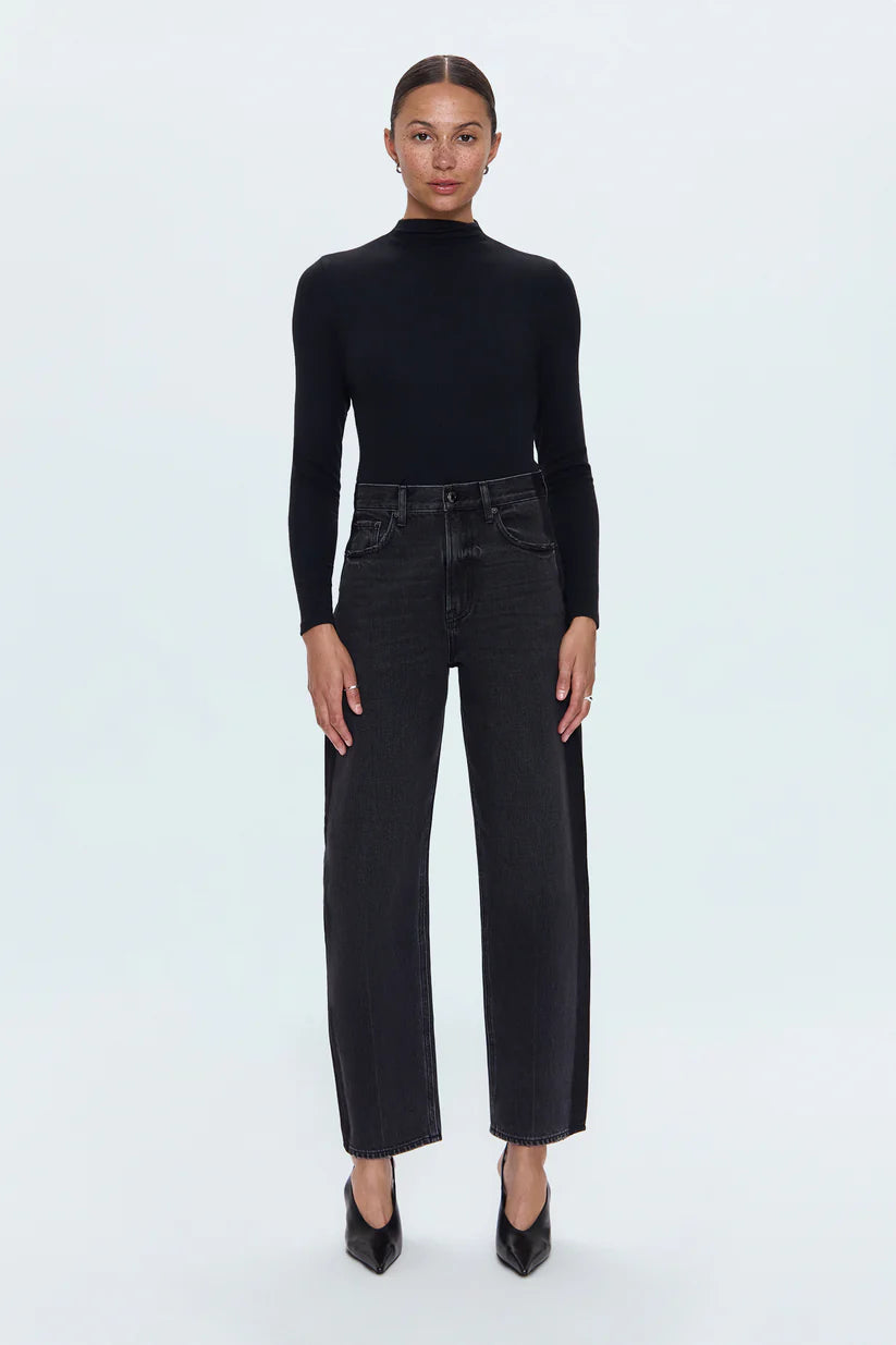 Person wearing a black turtleneck and black jeans on a white background