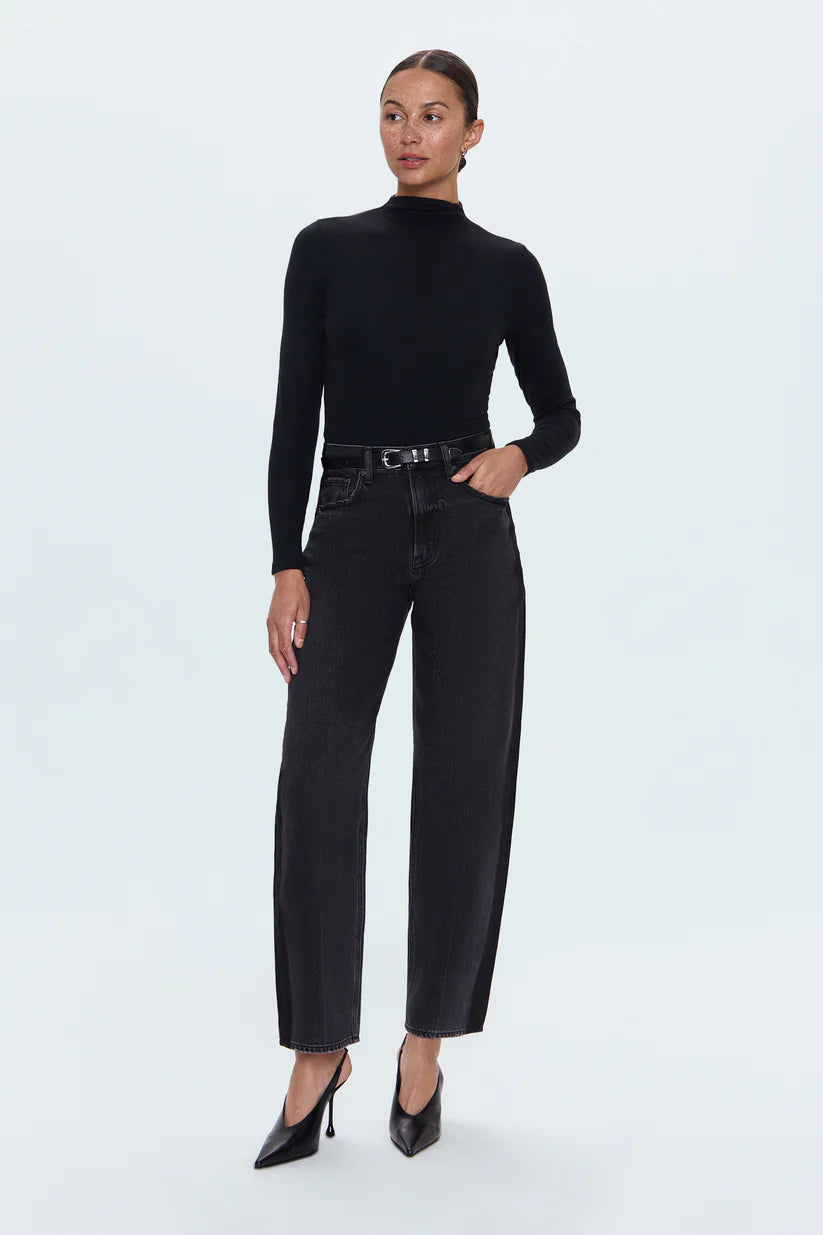 Woman wearing a black turtleneck and black jeans on a white background