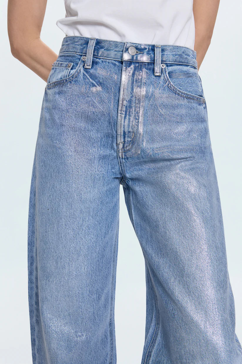 Blue jeans worn by a person on a light gray background
