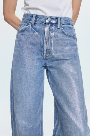 Blue jeans worn by a person on a light gray background