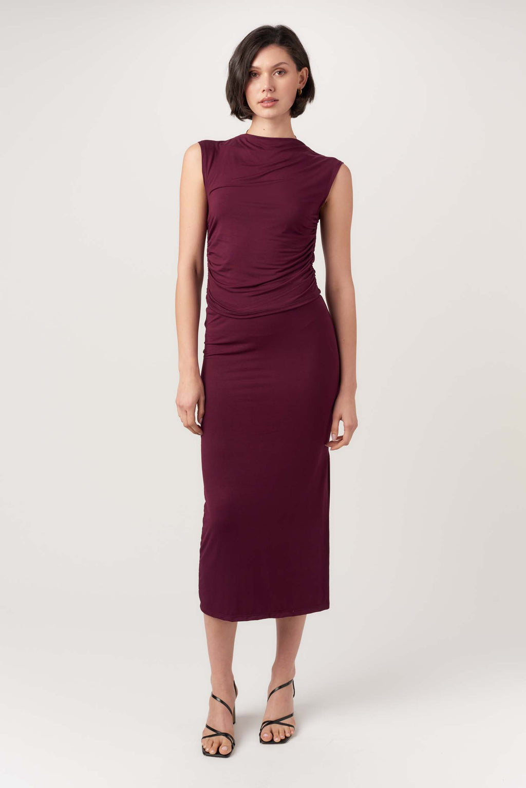 Woman wearing a burgundy dress on a white background