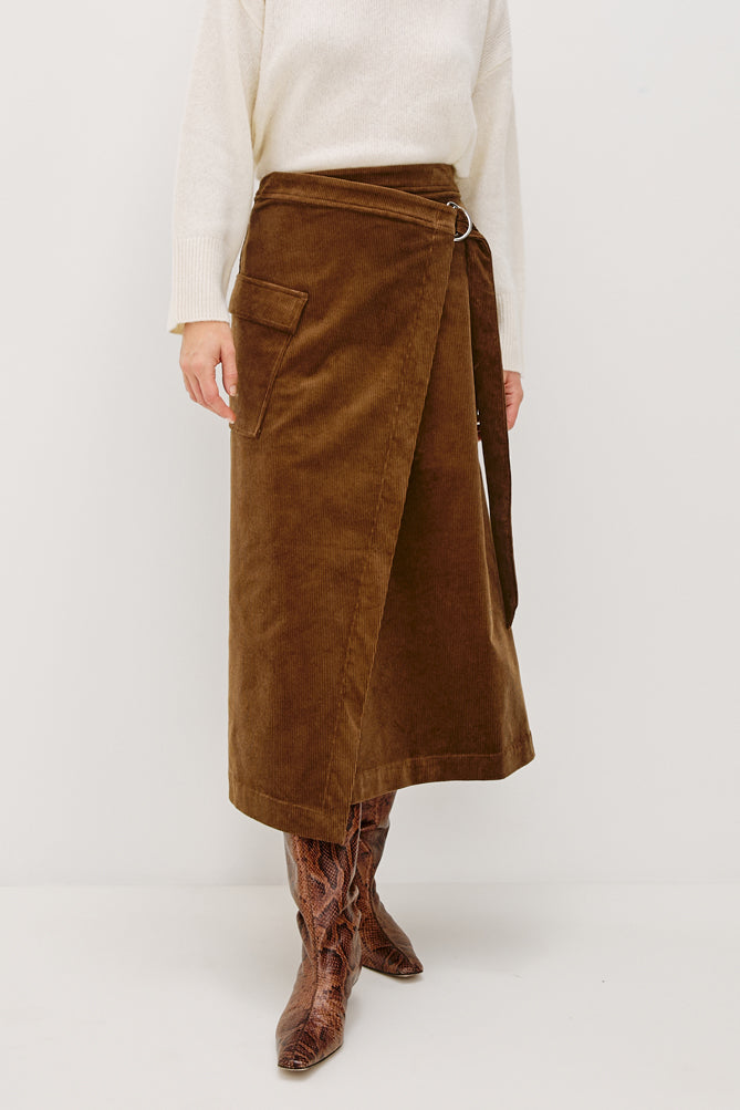 Brown wrap skirt worn by a person on a white background