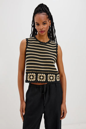 The Hazel is a cotton crochet tank with a cropped fit. Scallop detailing follows the neckline and arms, and a hand-crocheted panel lines the hem.