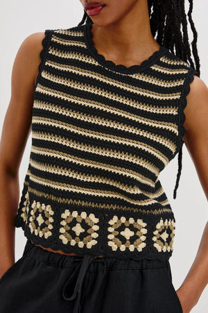 The Hazel is a cotton crochet tank with a cropped fit. Scallop detailing follows the neckline and arms, and a hand-crocheted panel lines the hem.