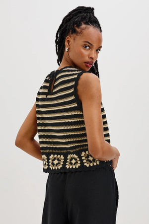 The Hazel is a cotton crochet tank with a cropped fit. Scallop detailing follows the neckline and arms, and a hand-crocheted panel lines the hem.