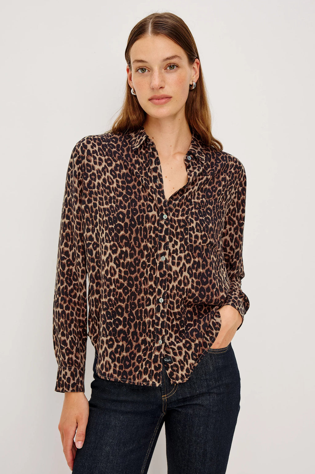 Woman wearing a leopard print shirt against a plain background