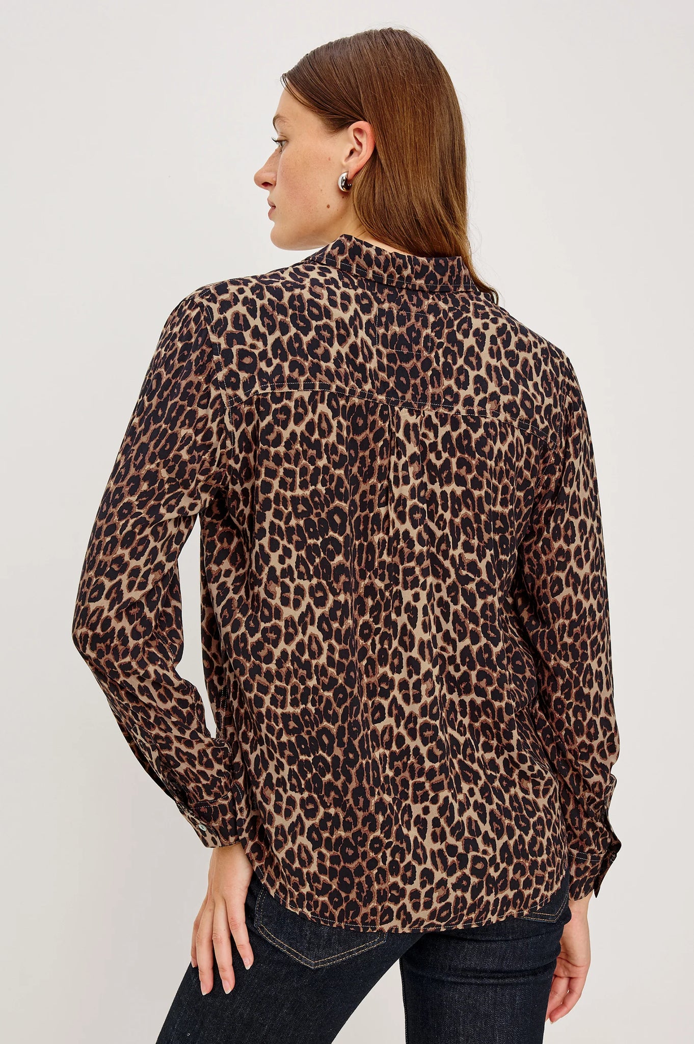 Woman wearing a leopard print blouse against a plain background