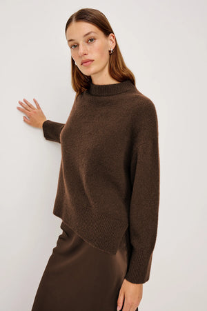 Woman wearing a brown sweater against a white background