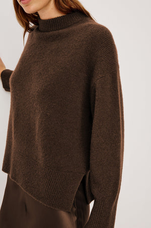 Brown sweater worn by a person on a white background