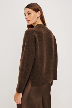 Woman wearing a brown jacket and skirt set on a white background