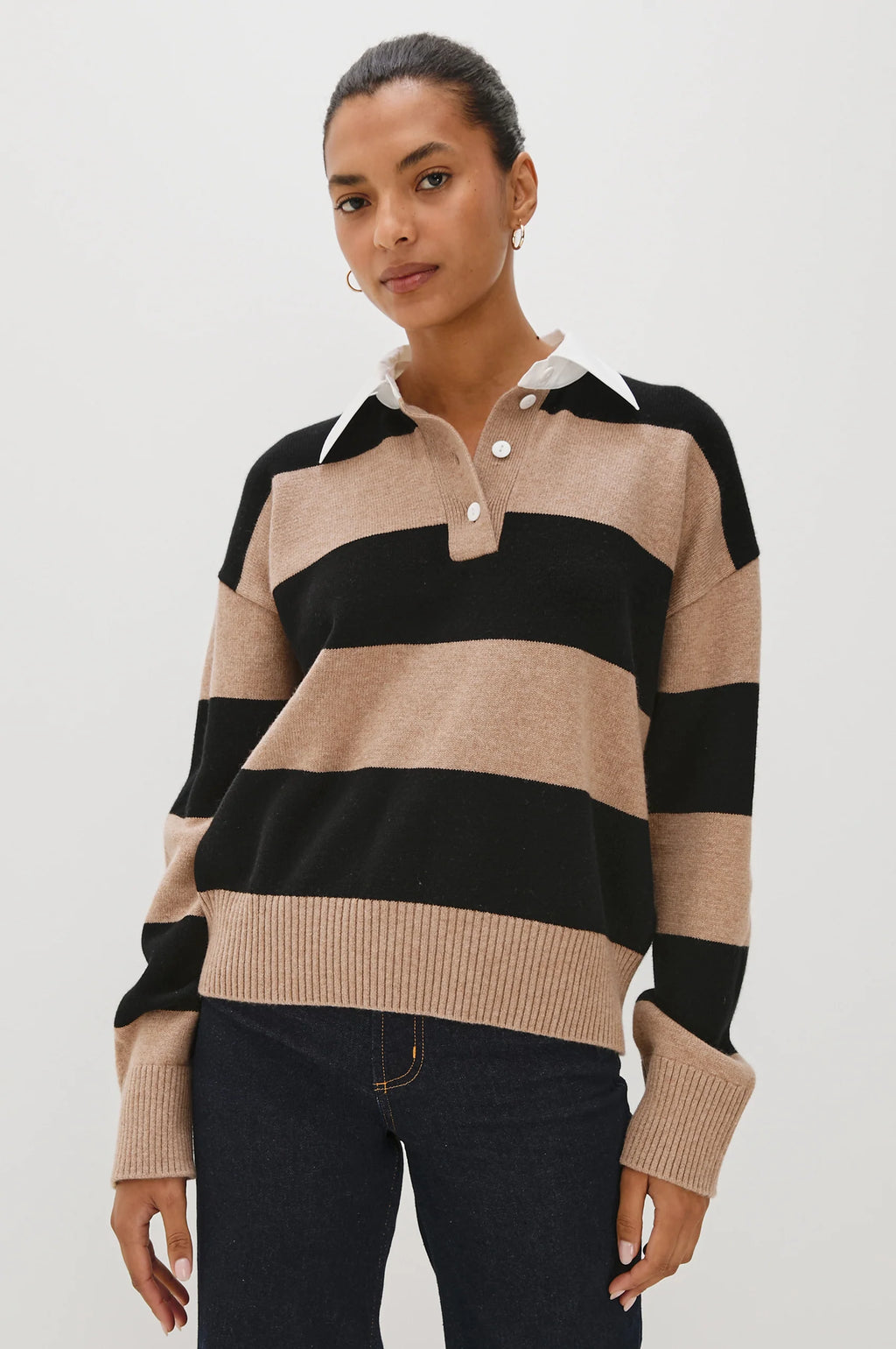 Woman wearing a beige and black striped sweater on a white background