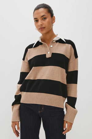 Woman wearing a beige and black striped sweater on a white background